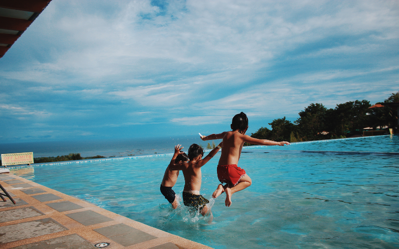 Kids jumping in a private resort pool